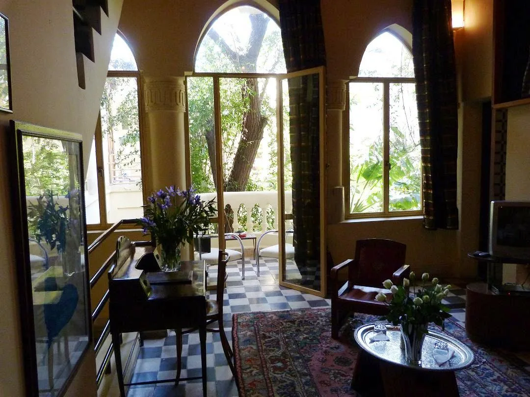 The living room of a junior suite at Riad Malika, opening onto the garden through tall arched windows