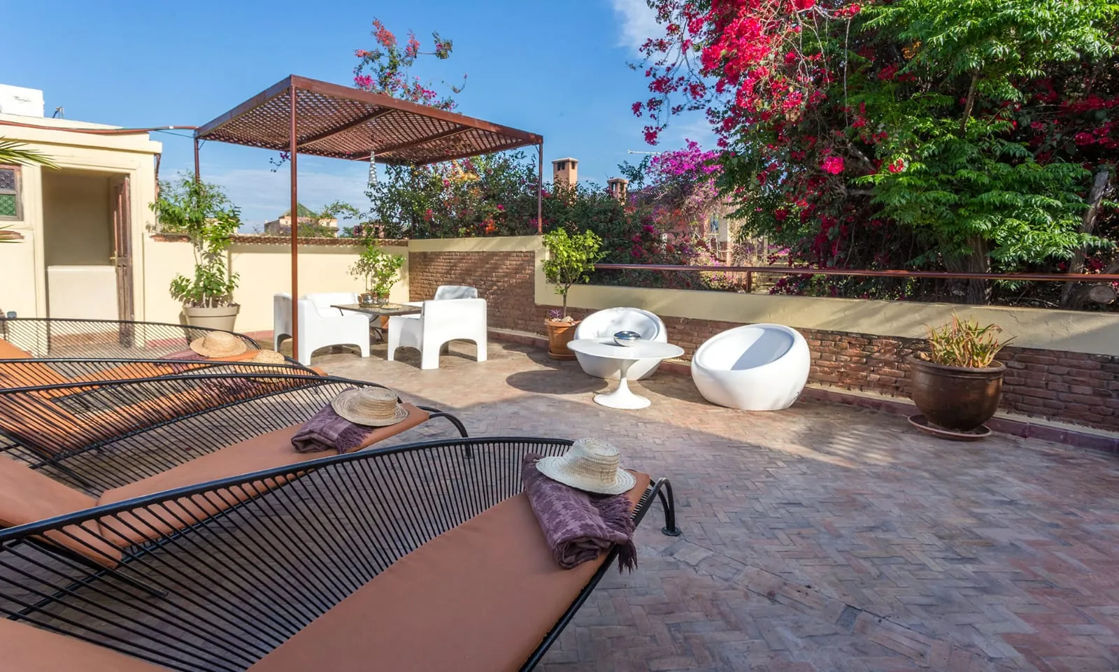 Riad Malika terrace with sun loungers, pergola and bougainvillea, on the rooftops of the Marrakech medina